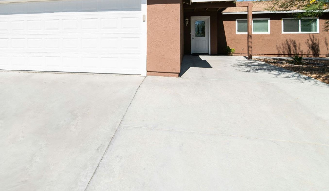 a house with a garage in the middle of a driveway